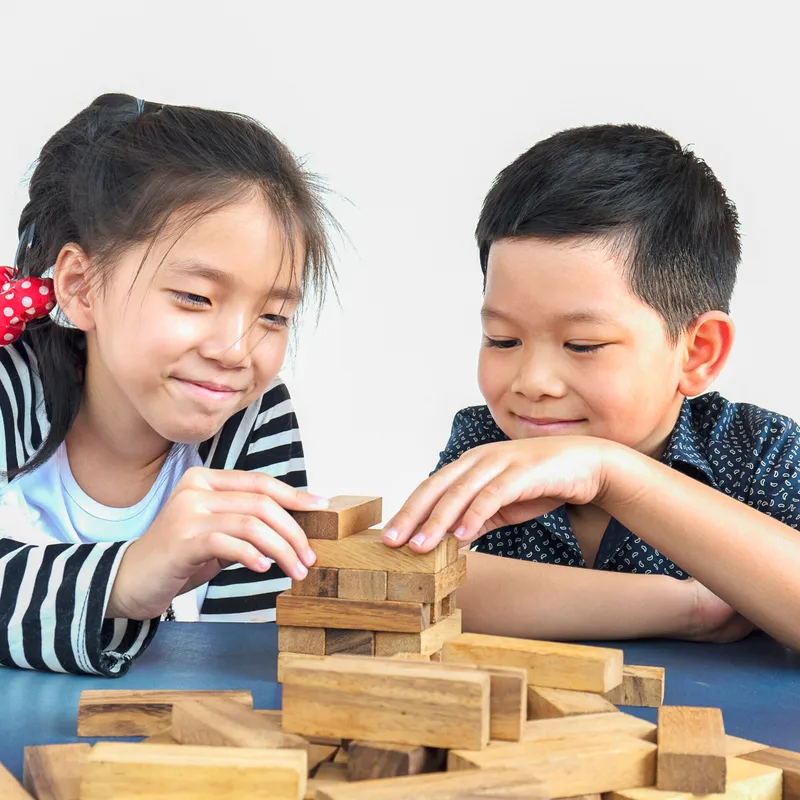 Children playing jenga, a wood blocks tower game